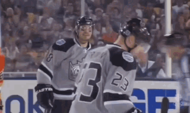 two hockey players wearing jerseys with the number 33 on them