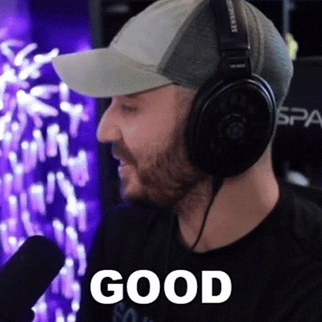 a man wearing headphones and a hat says " good "