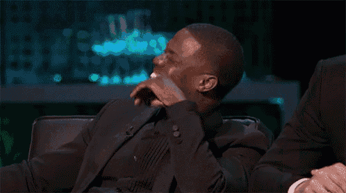 a man in a suit sits with his hand on his face