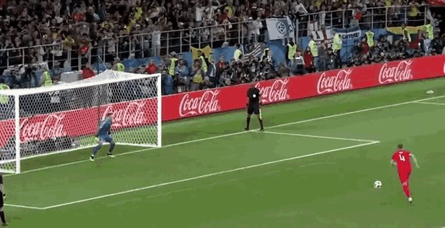 a soccer game is being played in front of coca cola banners