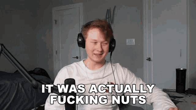 a man wearing headphones is sitting in front of a microphone and saying it was actually fucking nuts .