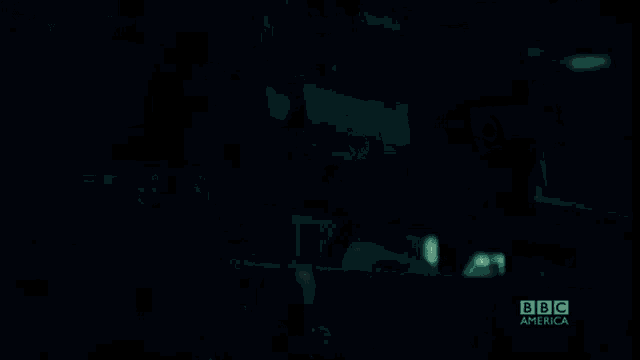 a woman in a dark room with bbc america written on the bottom right