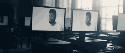a man is standing in front of a computer screen .