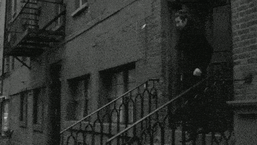 a black and white photo of a man walking up the stairs