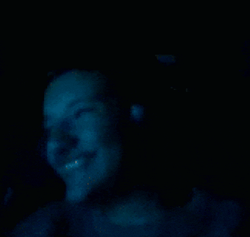 a man wearing headphones looks at the camera in a dark room .