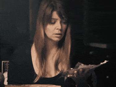 a woman is holding a piece of paper with the words what does all of this mean below her