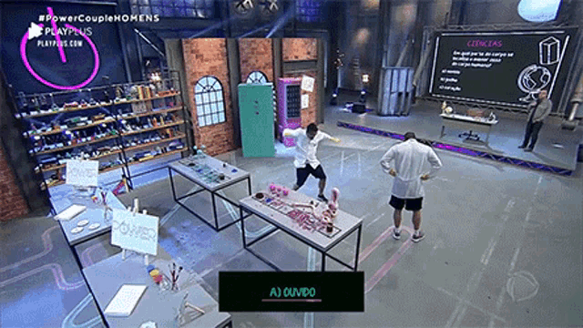 a man in a lab coat is standing in front of a table with a sign that says a ouvido
