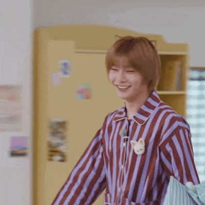 a young man wearing a striped shirt with a cat ear on it is smiling .