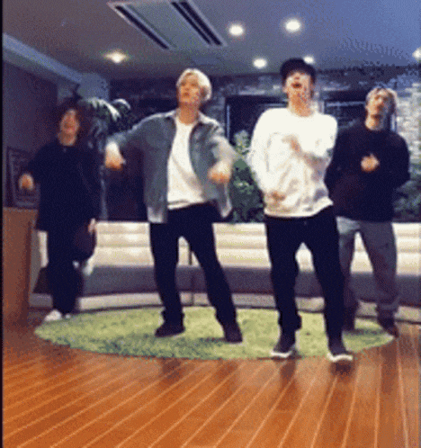 a group of young men are dancing in a living room .