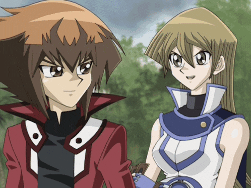 a boy and a girl standing next to each other in a park