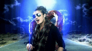a woman wearing sunglasses and a plaid scarf is walking down a road