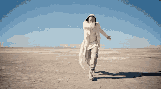 a man in a white coat is running across a desert