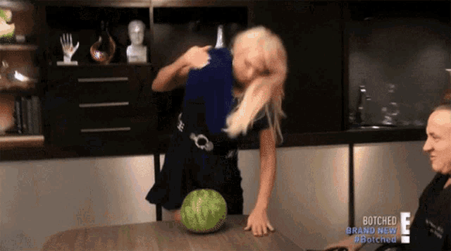 a woman is standing next to a watermelon on a table that says botched brand new on the bottom