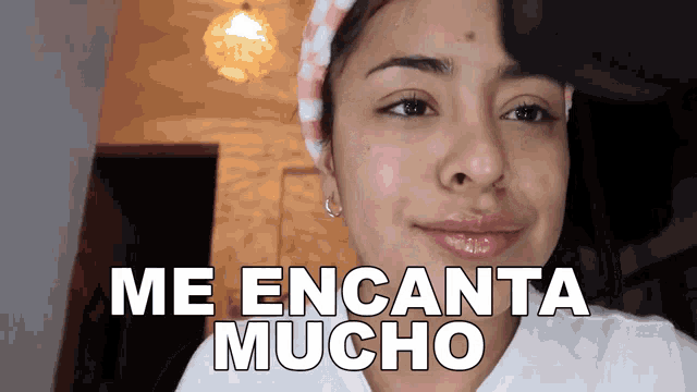 a woman with a headband on her head is smiling and says me encanta mucho