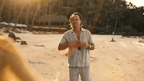 a man standing on a beach with the word max on the bottom right
