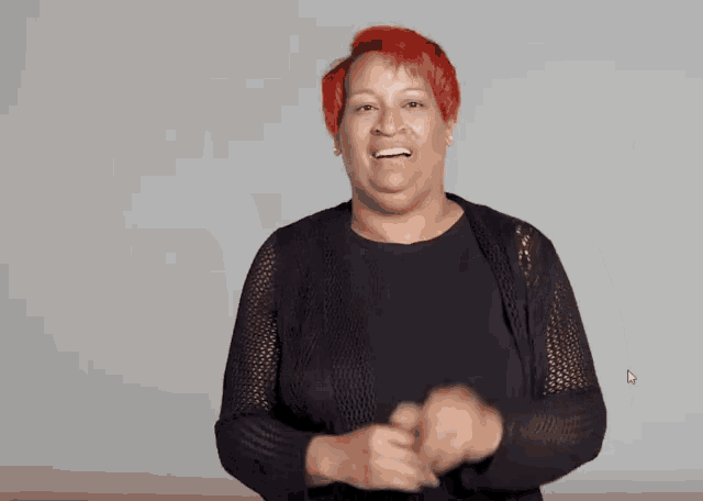 a woman with red hair is wearing a black shirt and a black cardigan