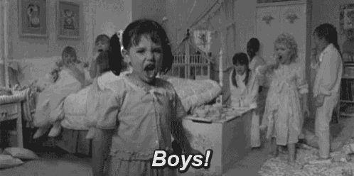 a black and white photo of a little girl screaming in a room with a group of children .