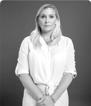 a woman in a white shirt has her hands folded