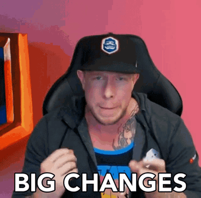 a man sitting in a chair with the words big changes written on his shirt