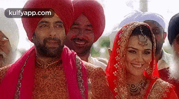 a bride and groom are posing for a picture with a group of people .