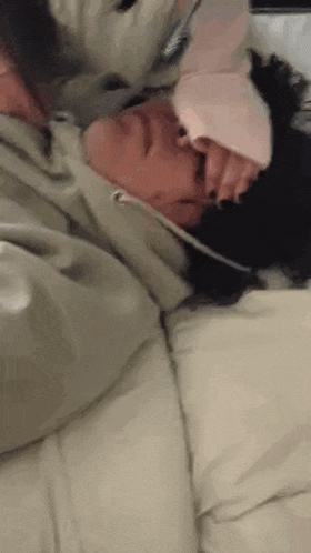a person is laying on a bed with a dog .
