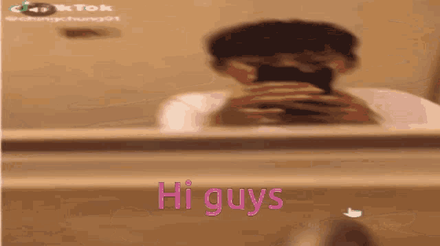 a person is taking a picture of themselves in a mirror with the words hi guys written on the bottom .
