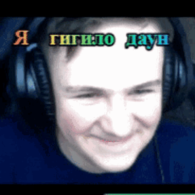 a man wearing headphones is smiling in a video with russian writing on the bottom