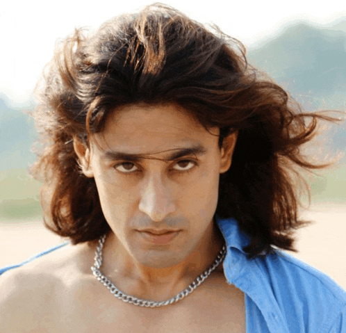 a man with long hair and a silver chain around his neck