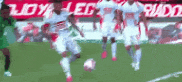 a group of soccer players are playing soccer on a field