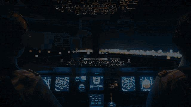 two pilots are in the cockpit of a plane with the letters n and m visible