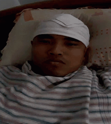 a man wearing a white headband is laying in bed