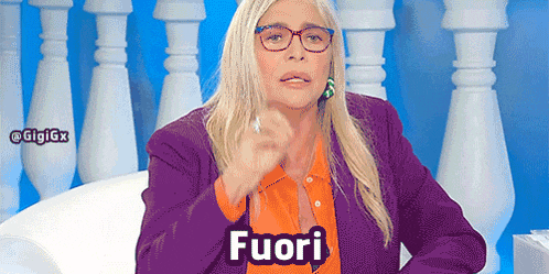 a woman wearing glasses and a purple jacket has the word fuori on her chest