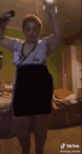 a woman is singing into a microphone while dancing in a room .