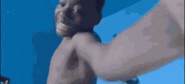 a shirtless man is being punched in the face while having a video call with someone .