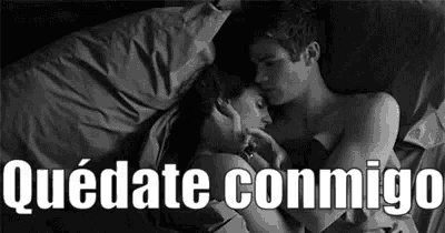 a black and white photo of a man and a woman hugging in bed .