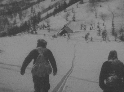 a black and white photo of two people skiing down a snow covered hill