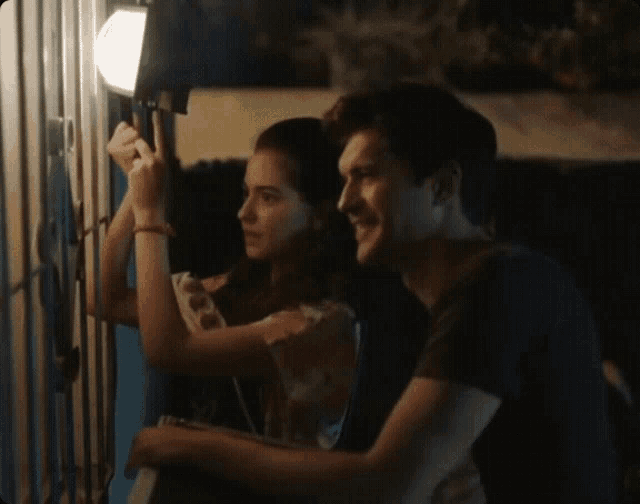 a man and a woman are standing next to each other at night
