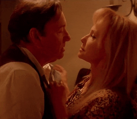 a man and a woman are kissing each other in a room .