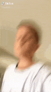a blurry picture of a man taking a selfie with a white shirt on .