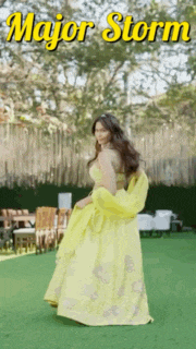 a woman in a yellow dress is standing on a green lawn with the words major storm written above her