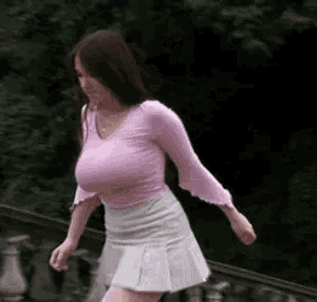 a woman with very large breasts is walking down a set of stairs .