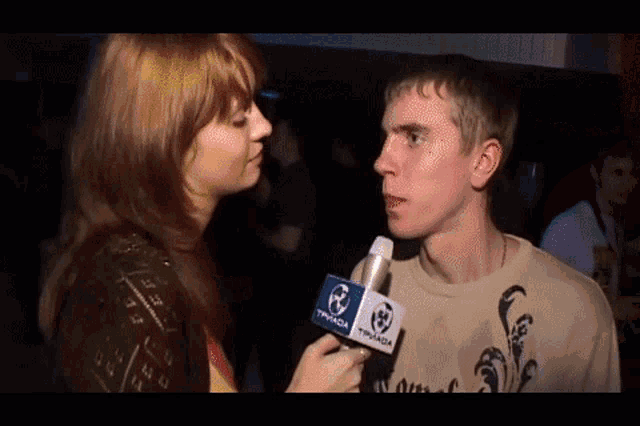 a woman is talking to a man with a microphone that says typada