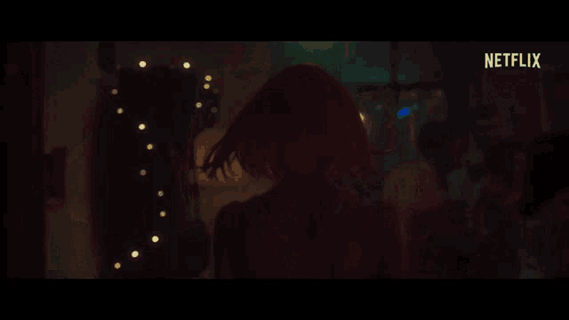 a man with red hair is dancing with a woman in a wig in a dark room .