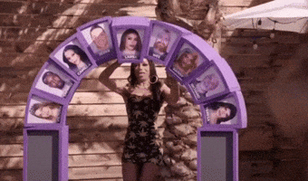 a woman is standing in front of a purple arch with pictures of people