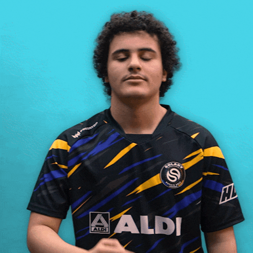a man wearing a black and yellow shirt with aldi written on it