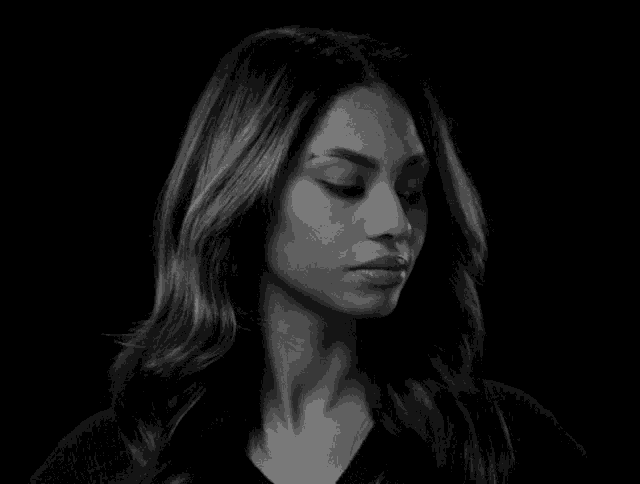 a black and white photo of a woman in a black shirt