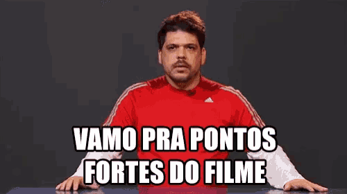 a man in a red shirt says vamos pra pontos fortes do filme while sitting at a table
