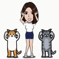 a woman is standing next to two cats .