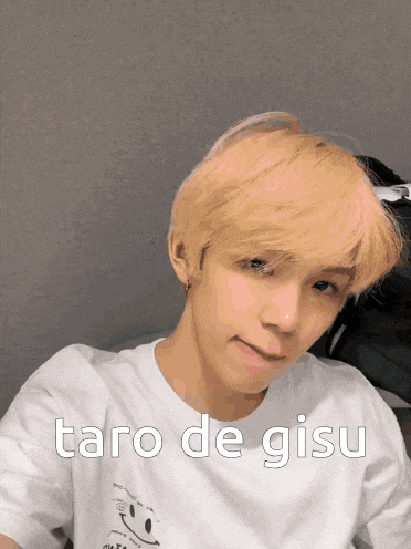 a young man with blonde hair is wearing a white t-shirt that says " taro de gisu " on it