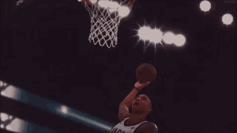 a basketball player wearing a jersey that says buckeyes is dunking the ball
